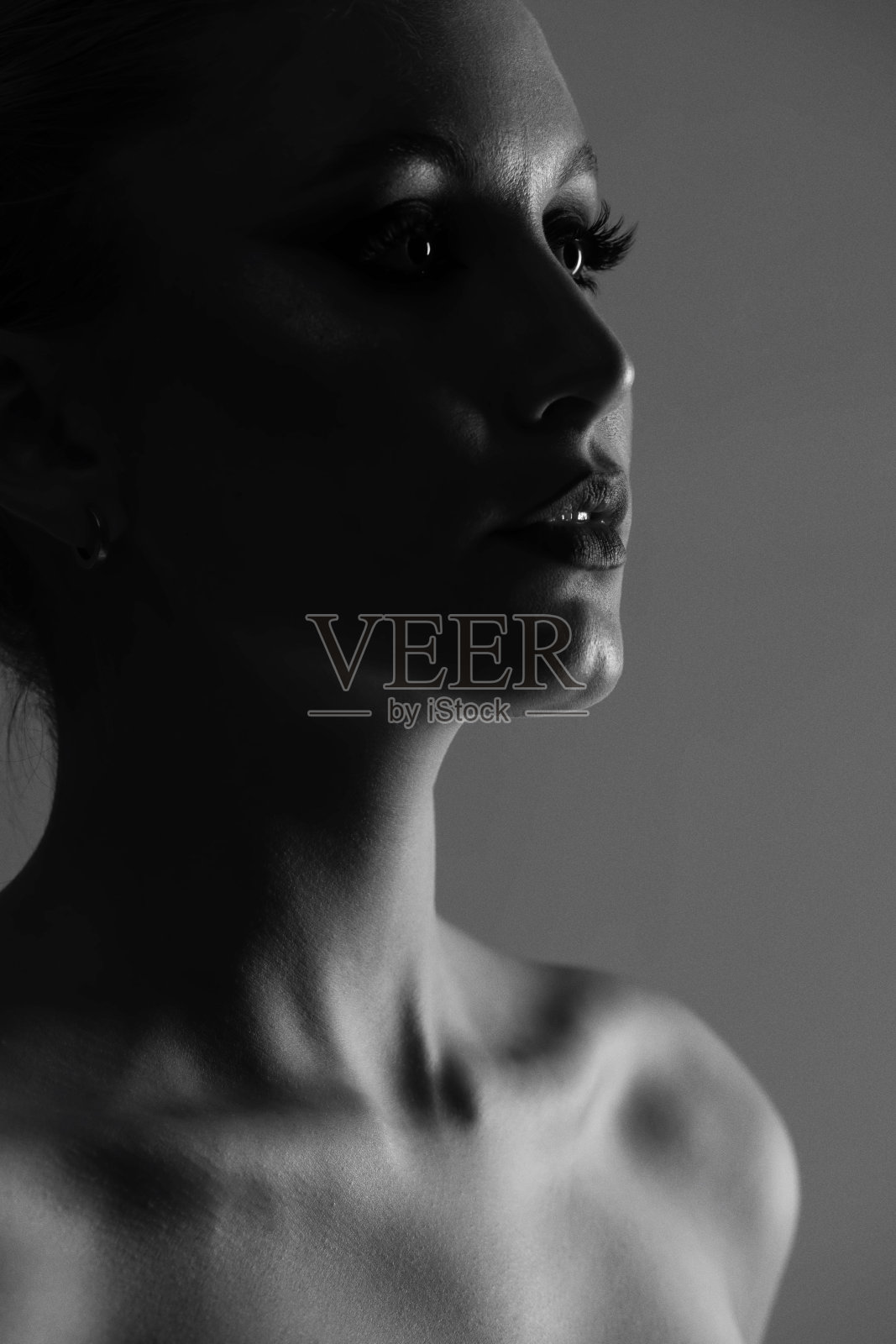 美丽的女人黑暗剪影工作室肖像在灰色的背景照片摄影图片