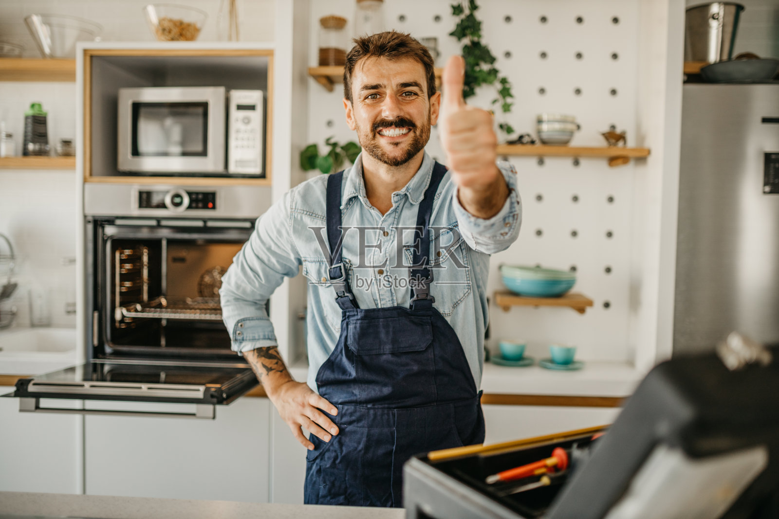 专注的工匠熟练地用螺丝刀组装厨房抽屉，体现了木工的效率和专业知识照片摄影图片