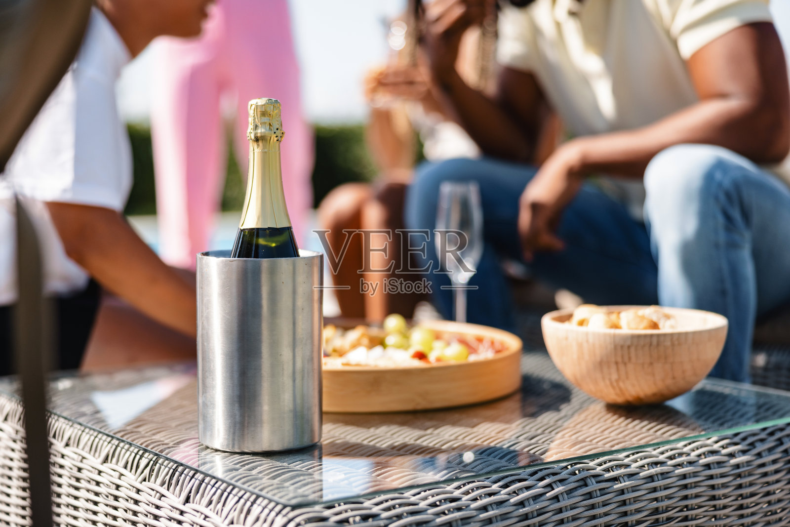 在户外夏日派对上，一瓶香槟酒在冷藏箱里和一些小吃的特写照片摄影图片