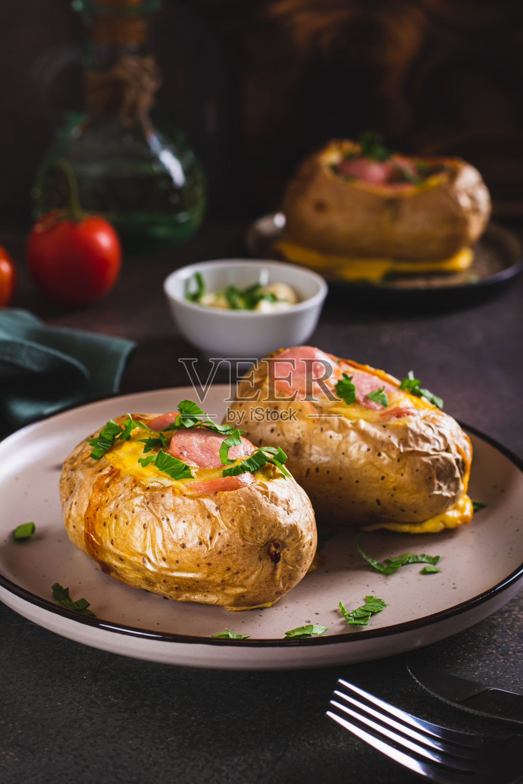 烤全土豆配鸡蛋，香肠和香草放在盘子里照片摄影图片