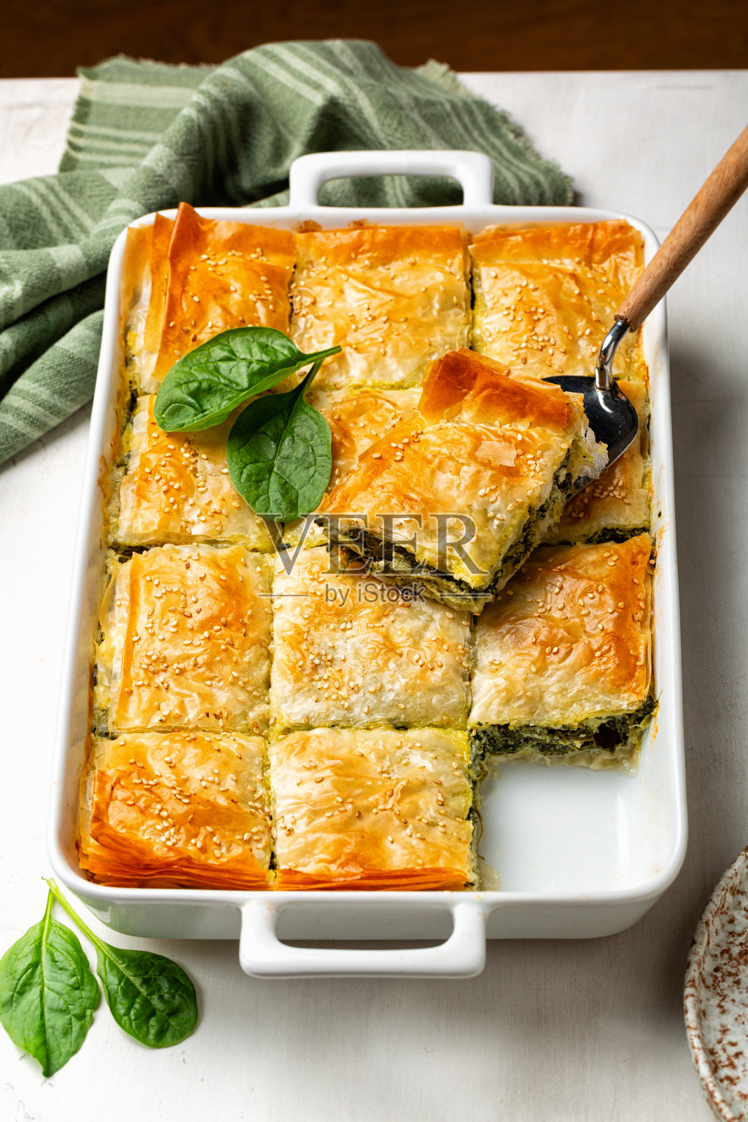 砂锅菠菜馅饼，自制的希腊美味菠菜派，包含奶酪羊乳酪，切碎的菠菜，绿色，鸡蛋，分层在菲罗或菲罗糕点。垂直的图像。照片摄影图片