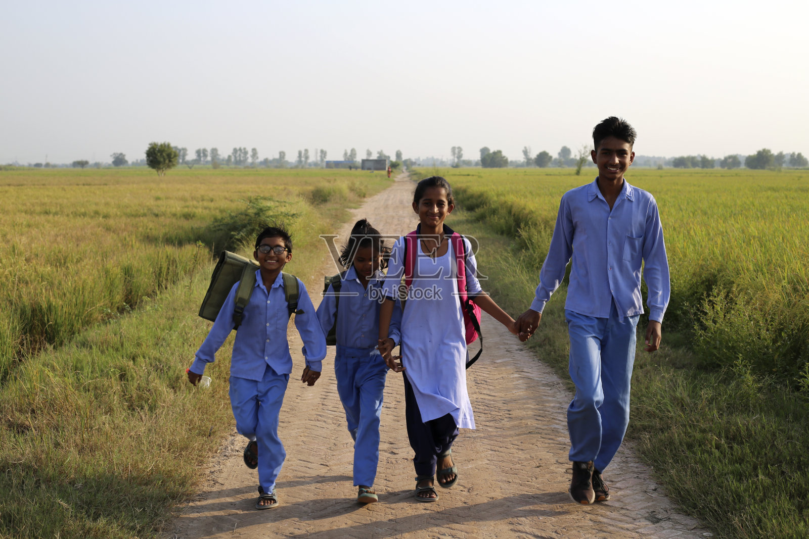 小学生放假后走在乡间小路上照片摄影图片