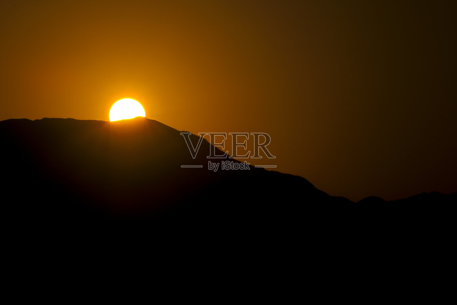 黎明时分，太阳从阿尔梅里亚加塔角的山上升起照片摄影图片