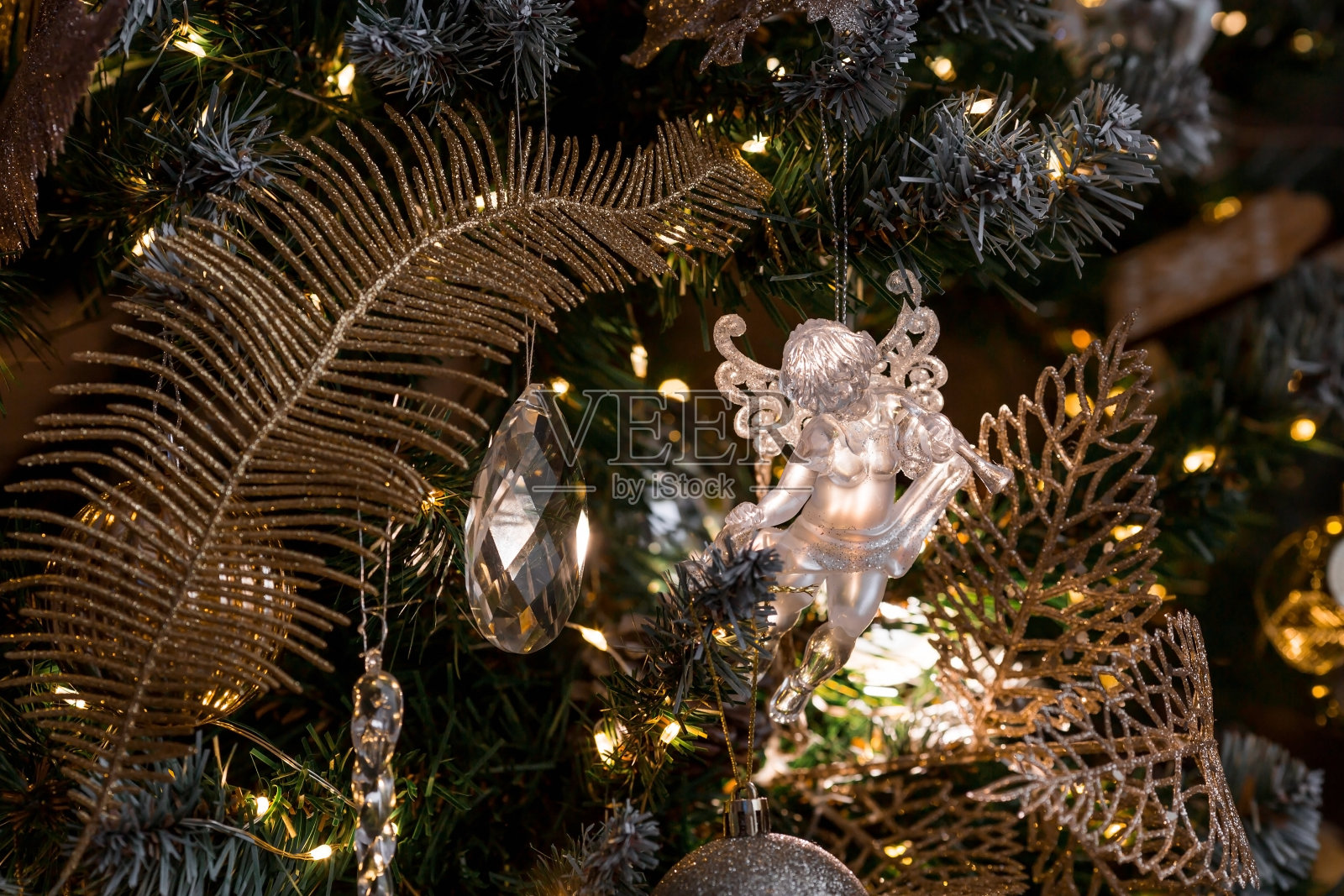 圣诞树上时尚的水晶透明天使。在室内装饰圣诞树的概念和时尚的新年和2024年圣诞节。照片摄影图片