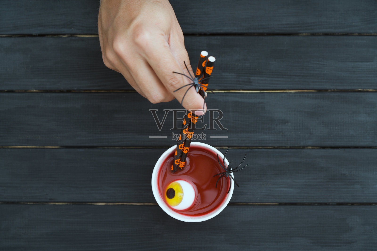 万圣节血鸡尾酒，眼球和蜘蛛在黑色的桌子上，俯视图照片摄影图片