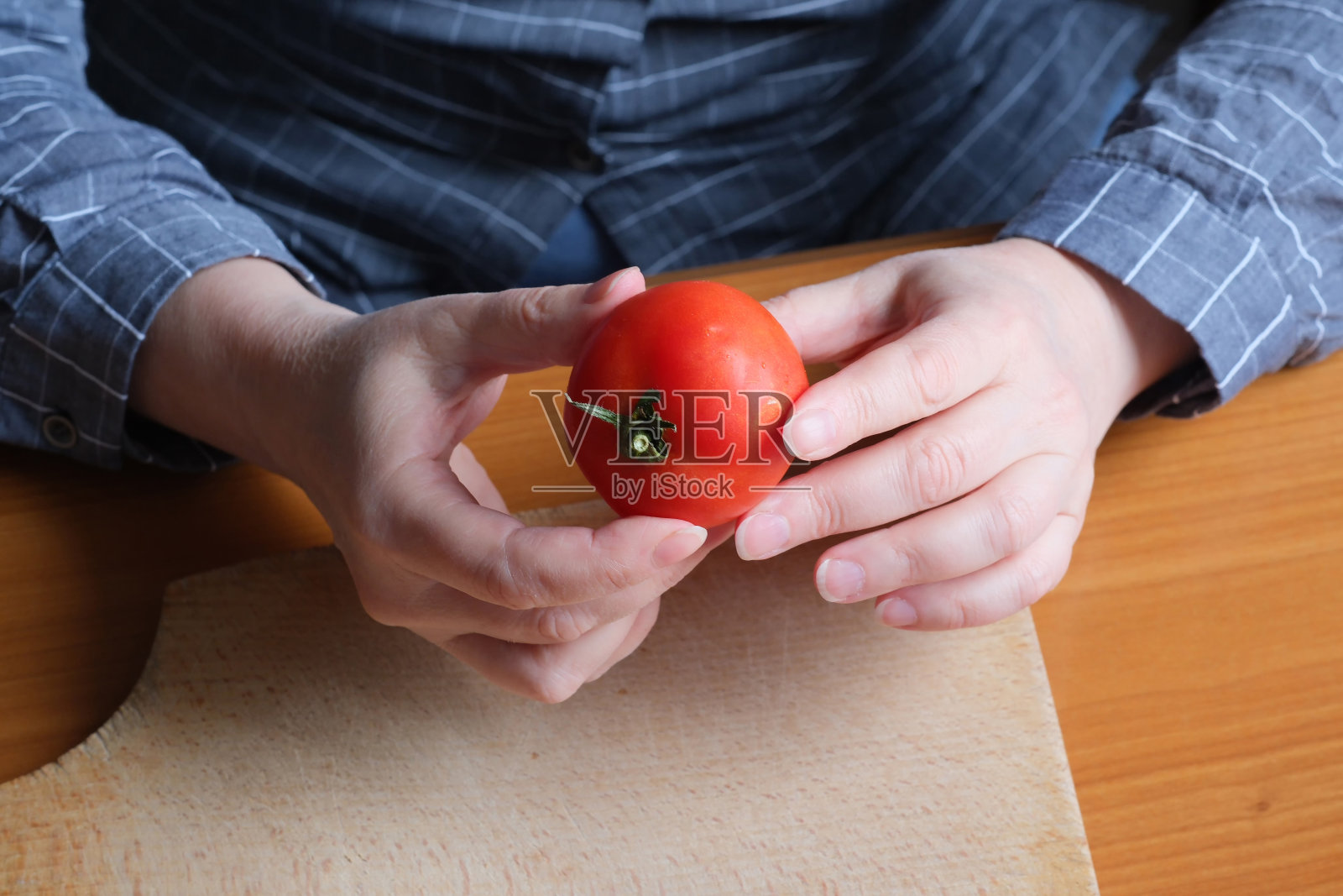 一位老妇人的手拿着一个熟透的红番茄照片摄影图片