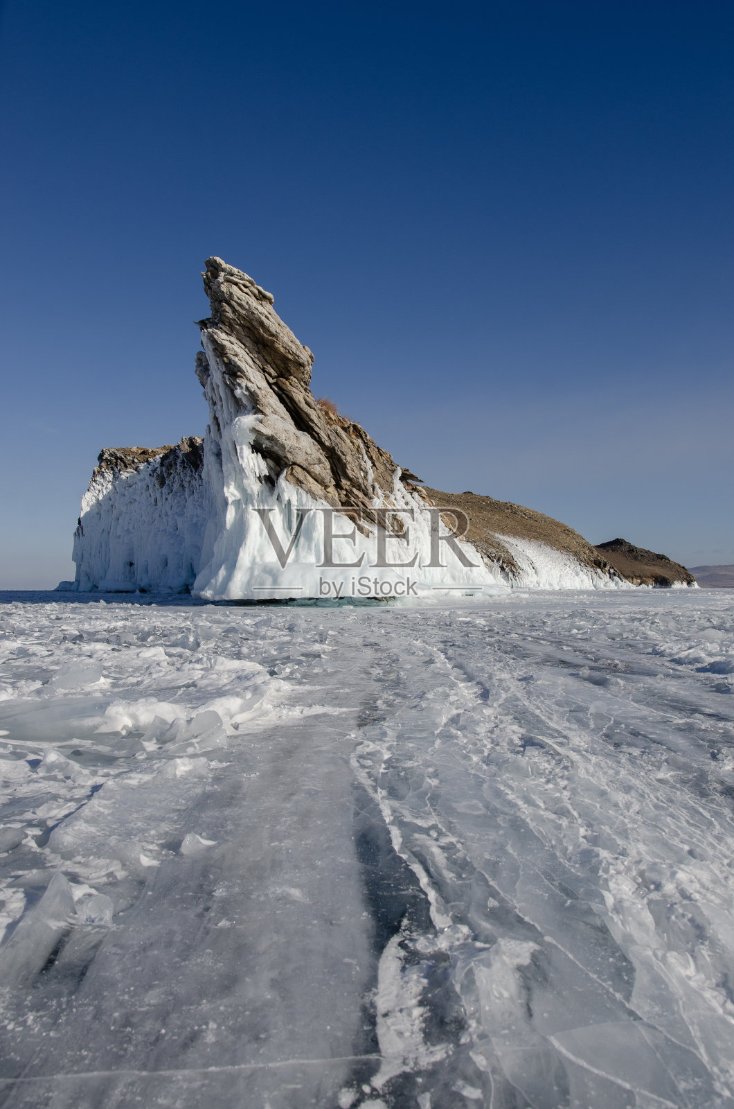 贝加尔湖是一个寒冷的冬日。最大的淡水湖。贝加尔湖上覆盖着冰雪，强烈的寒冷和霜冻，厚厚的清澈的蓝色冰。冰柱悬挂在岩石上。神奇的地方遗产照片摄影图片