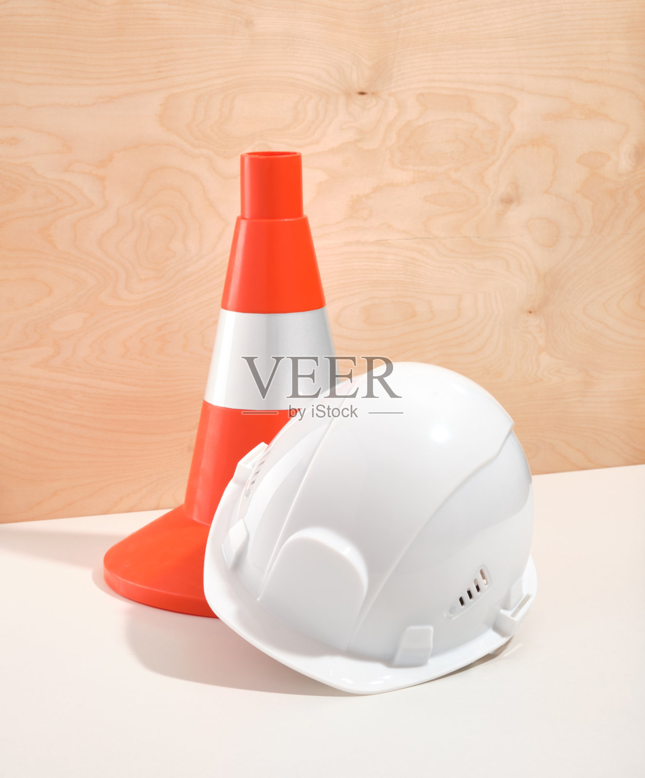 亮橙色施工锥和白色施工头盔保护。建设和努力工作。照片摄影图片