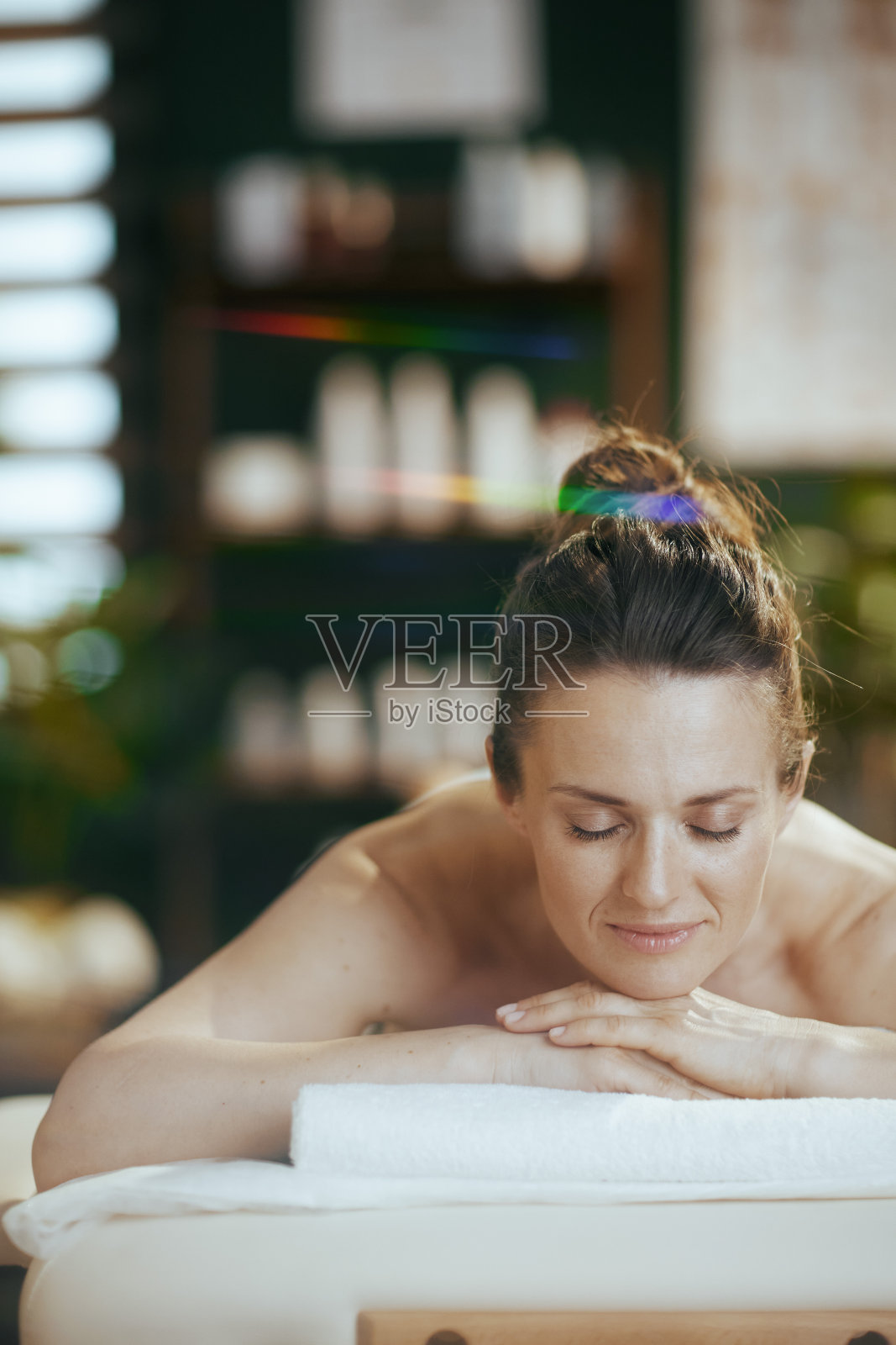 放松的现代女性在按摩柜中躺在按摩台上照片摄影图片