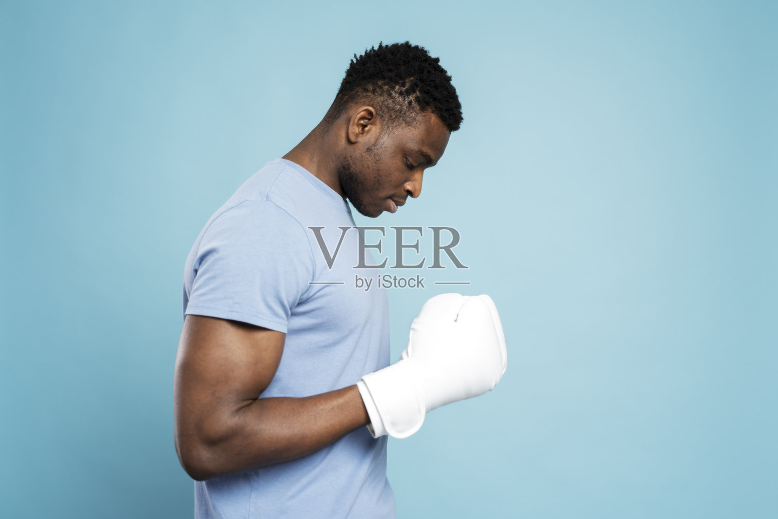 侧视图沉思有吸引力的非洲男子戴白色拳击手套孤立的蓝色背景照片摄影图片