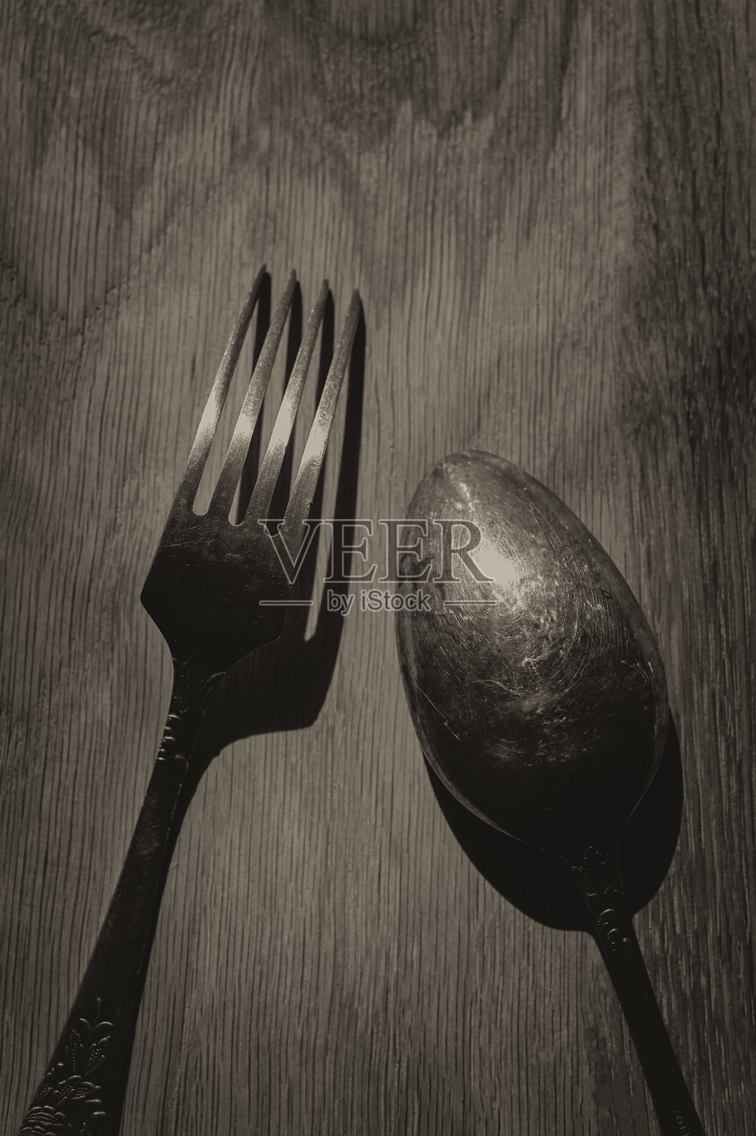 橡木板上的旧勺子和叉子。照片摄影图片