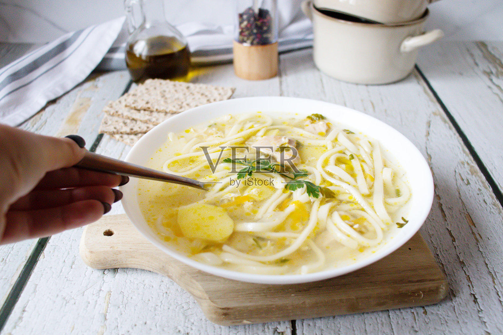 白色木桌上的白碗鸡汤面。晚餐照片摄影图片