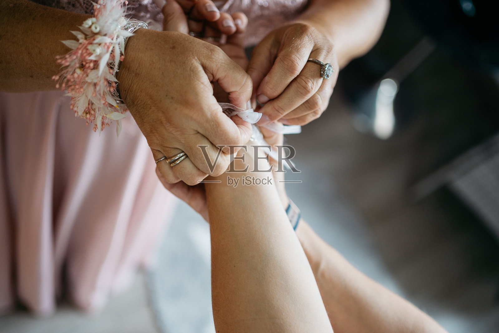 伴娘在新娘的手腕上包裹新娘的花束照片摄影图片