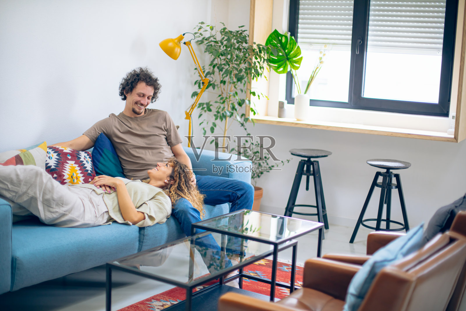 年轻夫妇在客厅沙发上放松地聊天照片摄影图片