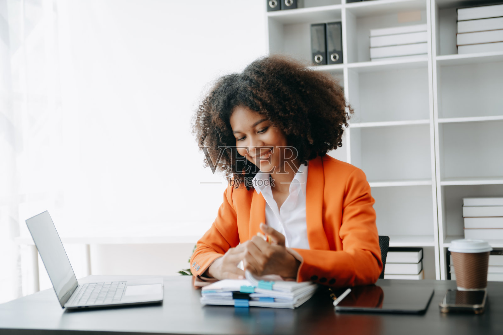 成功的非洲女商人在现代办公桌上用平板电脑和笔记本电脑分析财务税务、报告、会计、统计和分析研究概念照片摄影图片