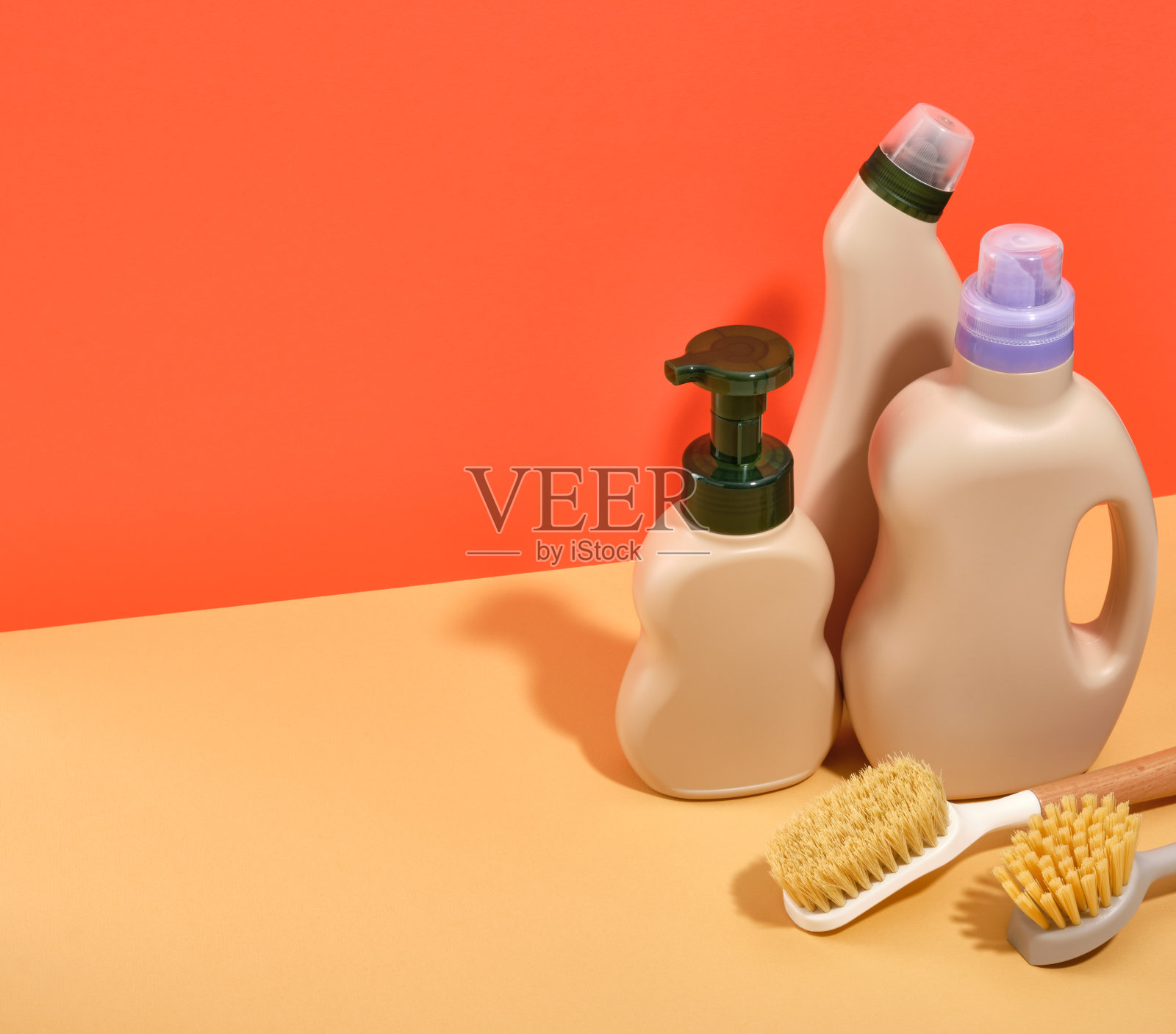 有效的洗涤剂和清洁剂在米色的瓶子和清洁刷。文本空间。照片摄影图片