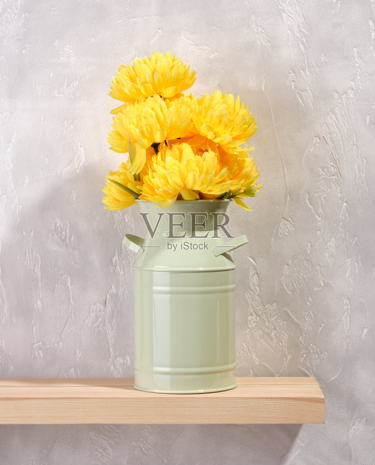 灰色的混凝土背景上，绿色的花瓶里插着一束美丽的黄花。春夏心情。照片摄影图片