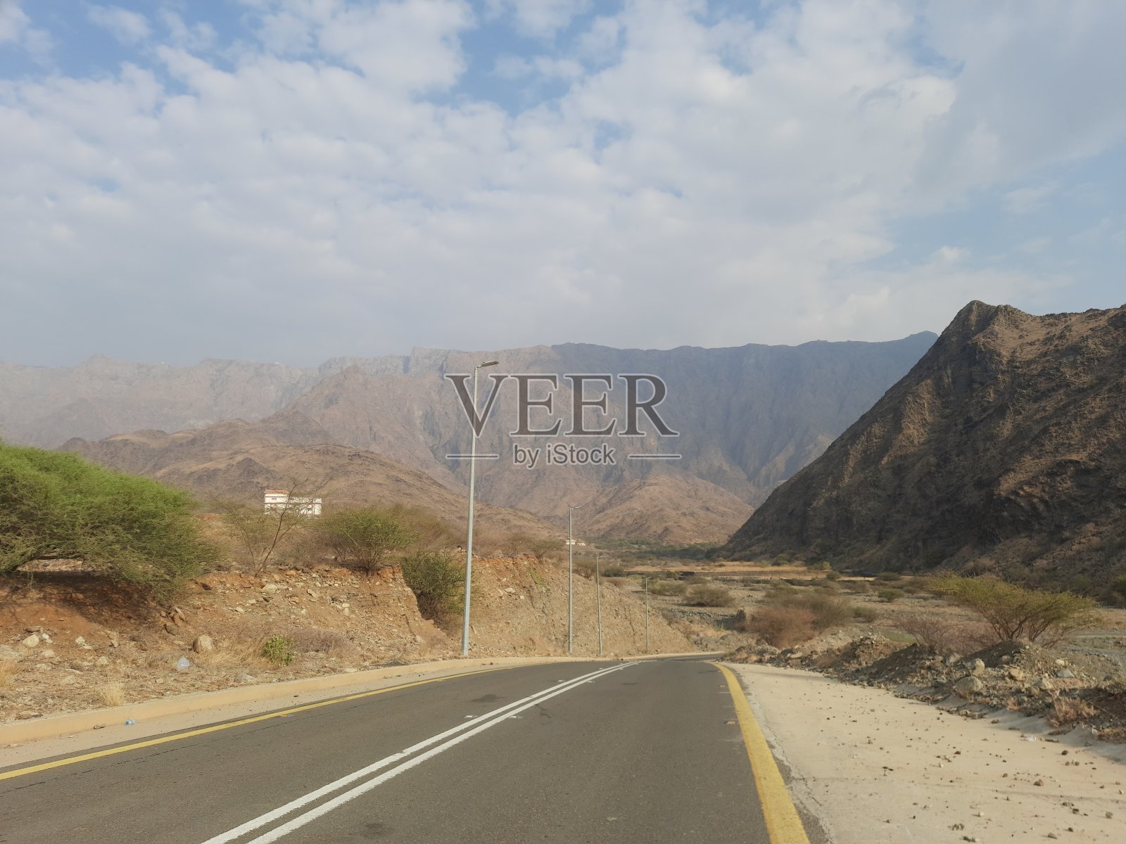 沙特阿拉伯Al-Baha，Al-Hujra市和Jarda Bin Ali村之间的山路，蓝天白云照片摄影图片