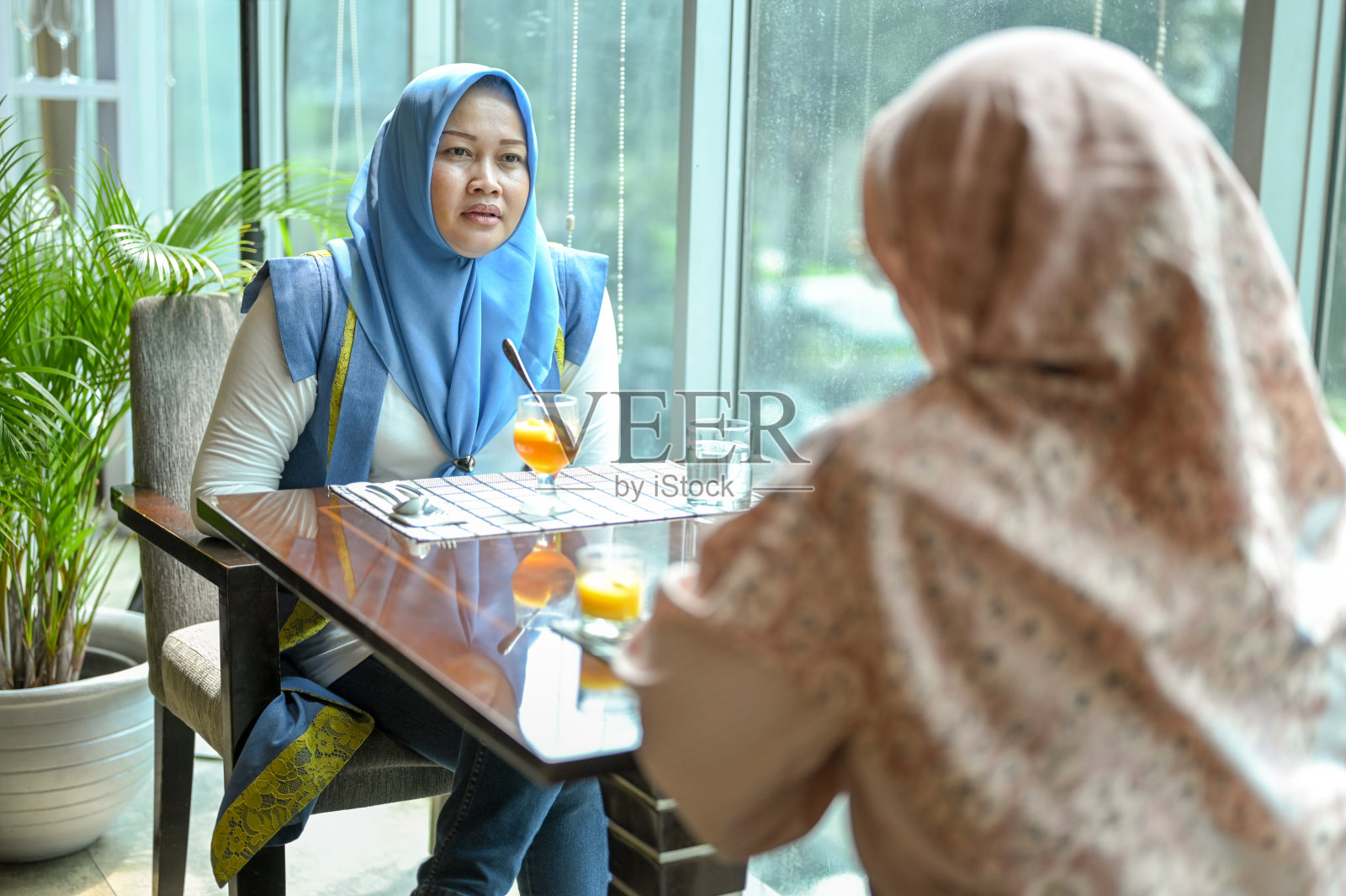 成熟的女人在窗边讨论照片摄影图片