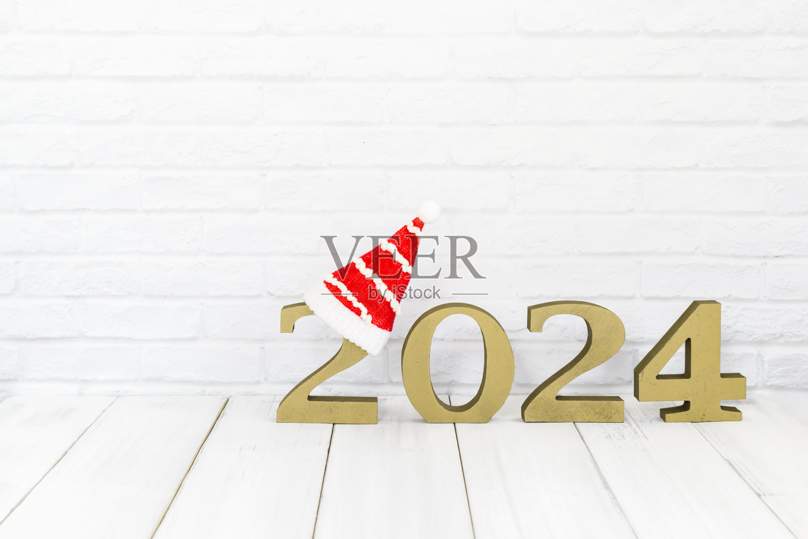 2024年新年和圣诞帽在白色背景上的白色木桌与复制空间照片摄影图片