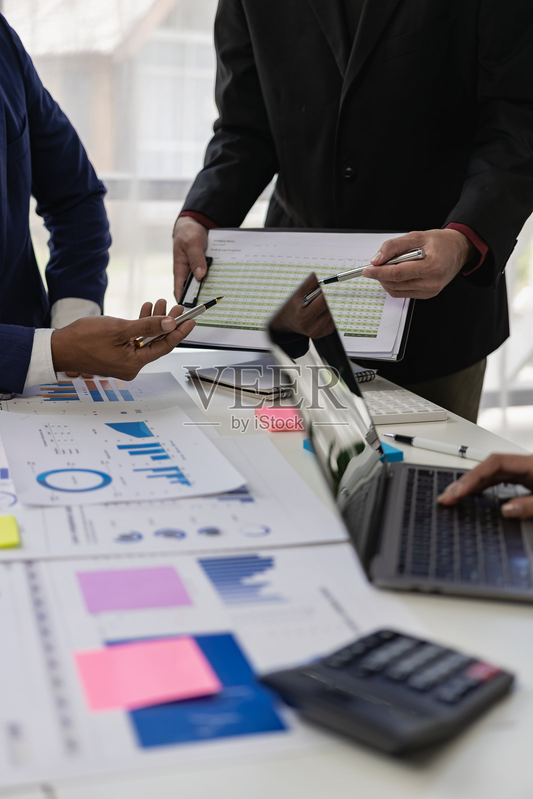 垂直图像，图表和收入图表使用笔记本电脑。业务分析和战略概念与业务顾问会面，讨论财务，特写照片照片摄影图片