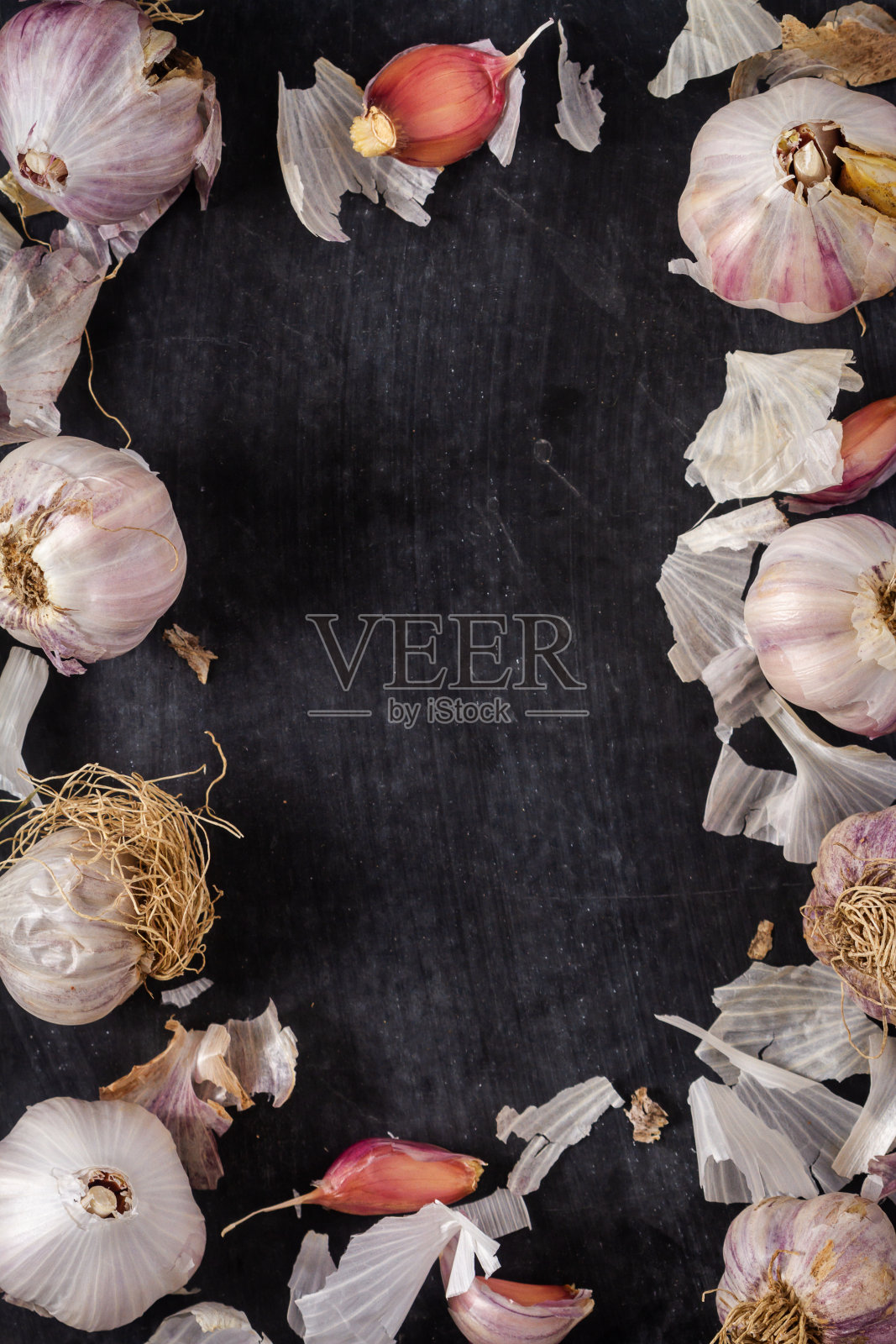 新鲜的大蒜鳞茎和丁香组合在黑色背景上照片摄影图片