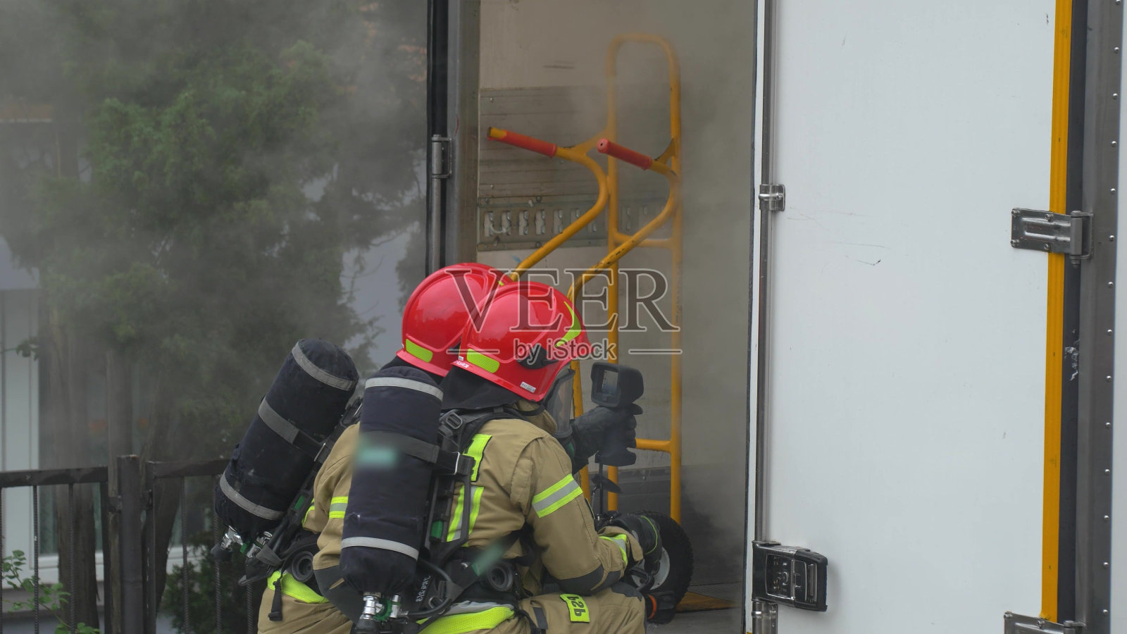 消防员在一辆浓烟弥漫的送货卡车上灭火照片摄影图片