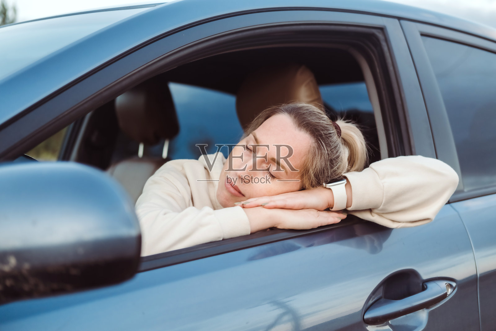 年轻疲惫的女人睡在车里的肖像，安全和驾驶的概念。照片摄影图片