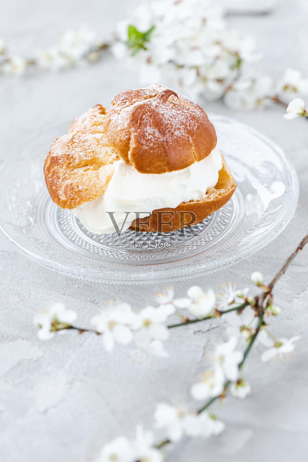 泡芙包，上面有鲜奶油和糖粉。泡芙点心甜点。法国奶油泡芙照片摄影图片
