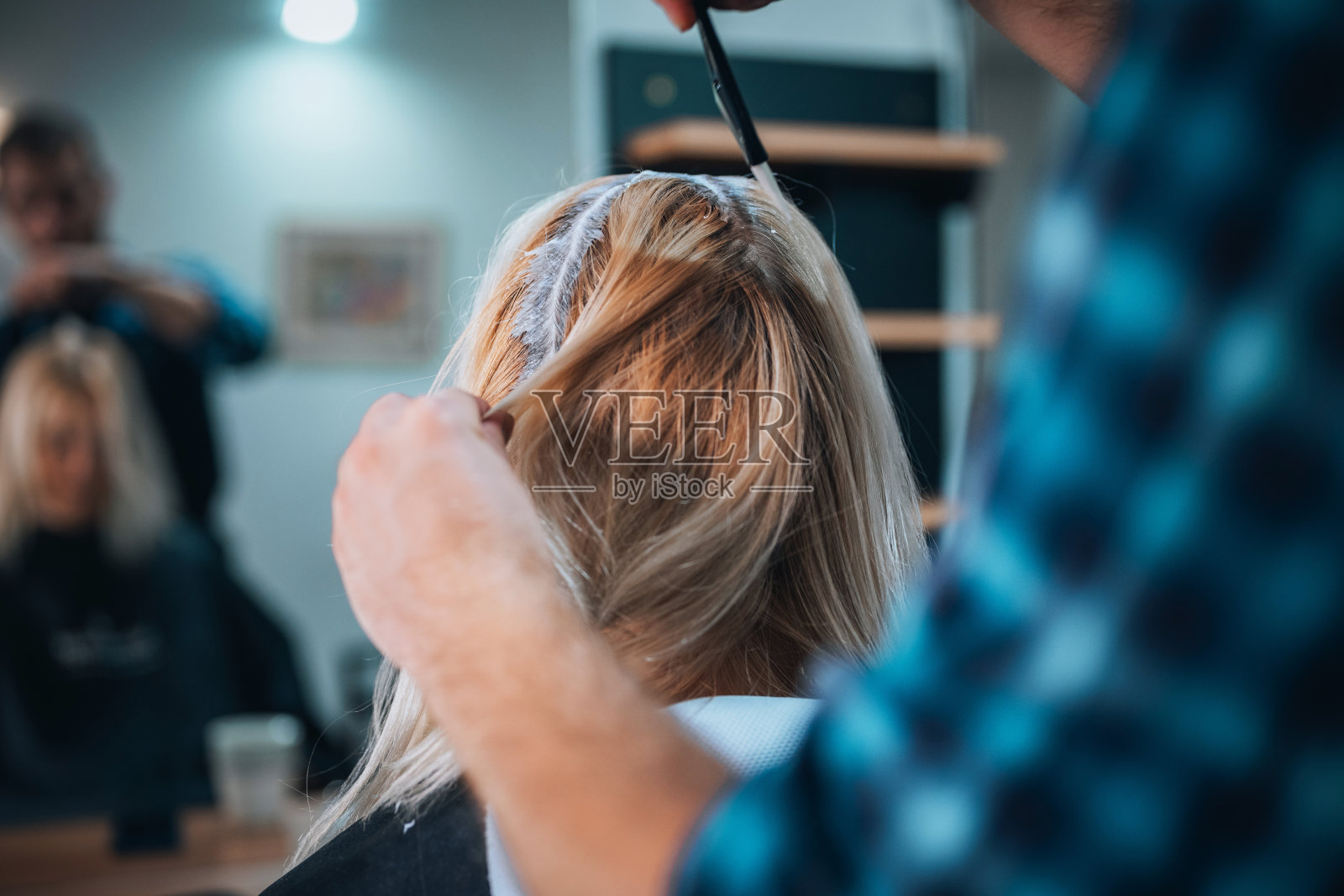 理发师用刷子给顾客的金发刷发根照片摄影图片