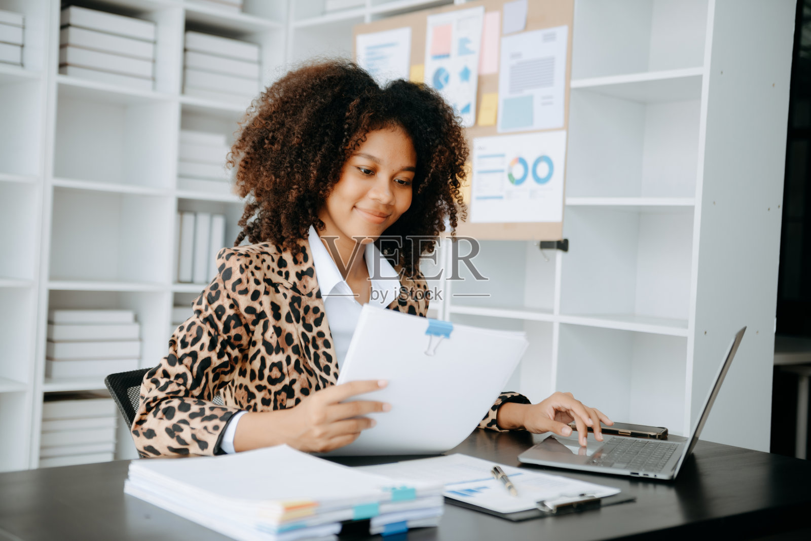 成功的非洲女商人在现代办公桌上用平板电脑和笔记本电脑分析财务税务、报告、会计、统计和分析研究概念照片摄影图片