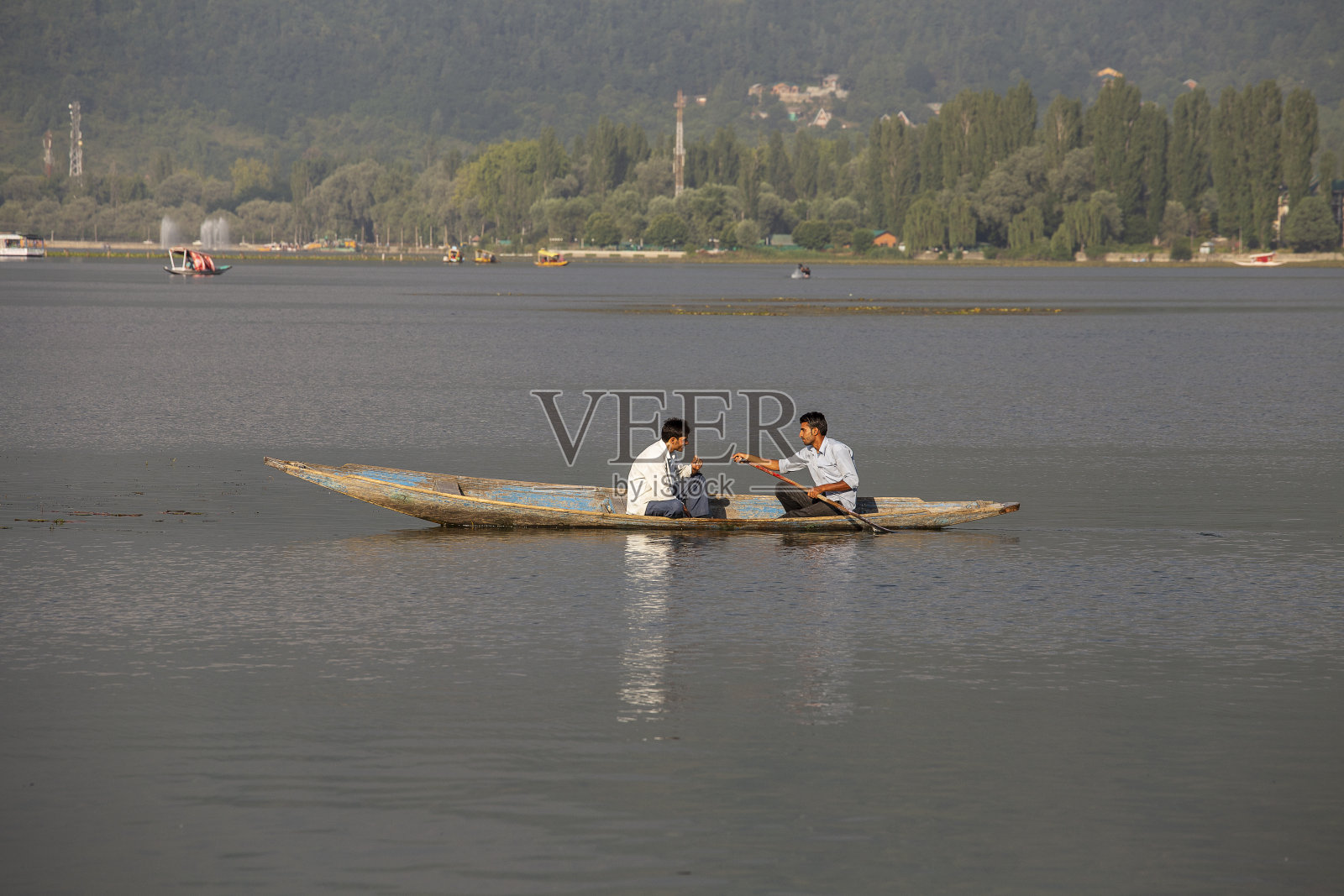 达尔湖的生活方式，当地人使用Shikara，一艘小船在印度斯利那加湖运输照片摄影图片