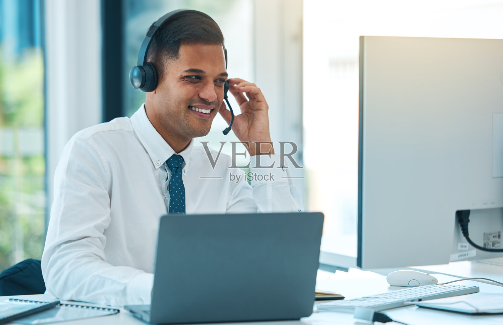 呼叫中心，电脑和人在客户服务，快乐和帮助台支持办公室。笔记本电脑，电话营销和销售代理的沟通，咨询或听取联系我们的客户关系管理业务照片摄影图片