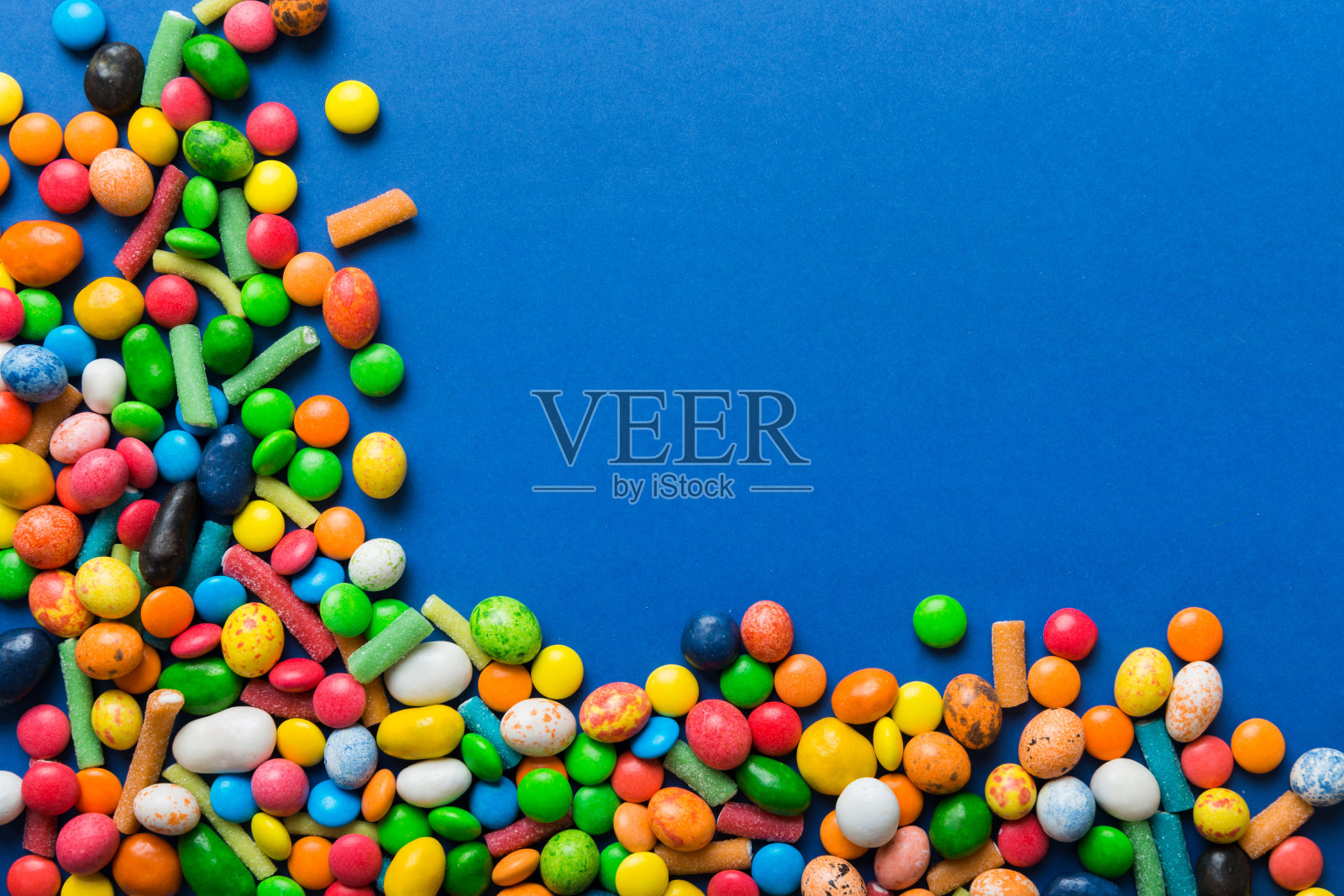 混合收集彩色糖果，在彩色背景。平躺，俯视图。框架的彩色巧克力涂层糖果照片摄影图片