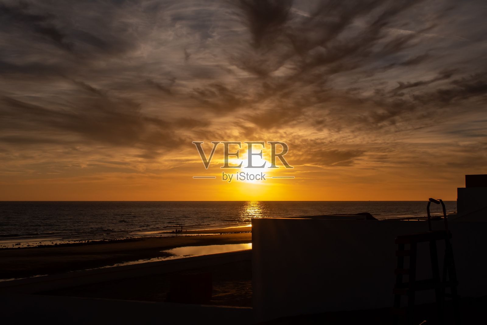 在宁静的海面上欣赏美丽的日落照片摄影图片