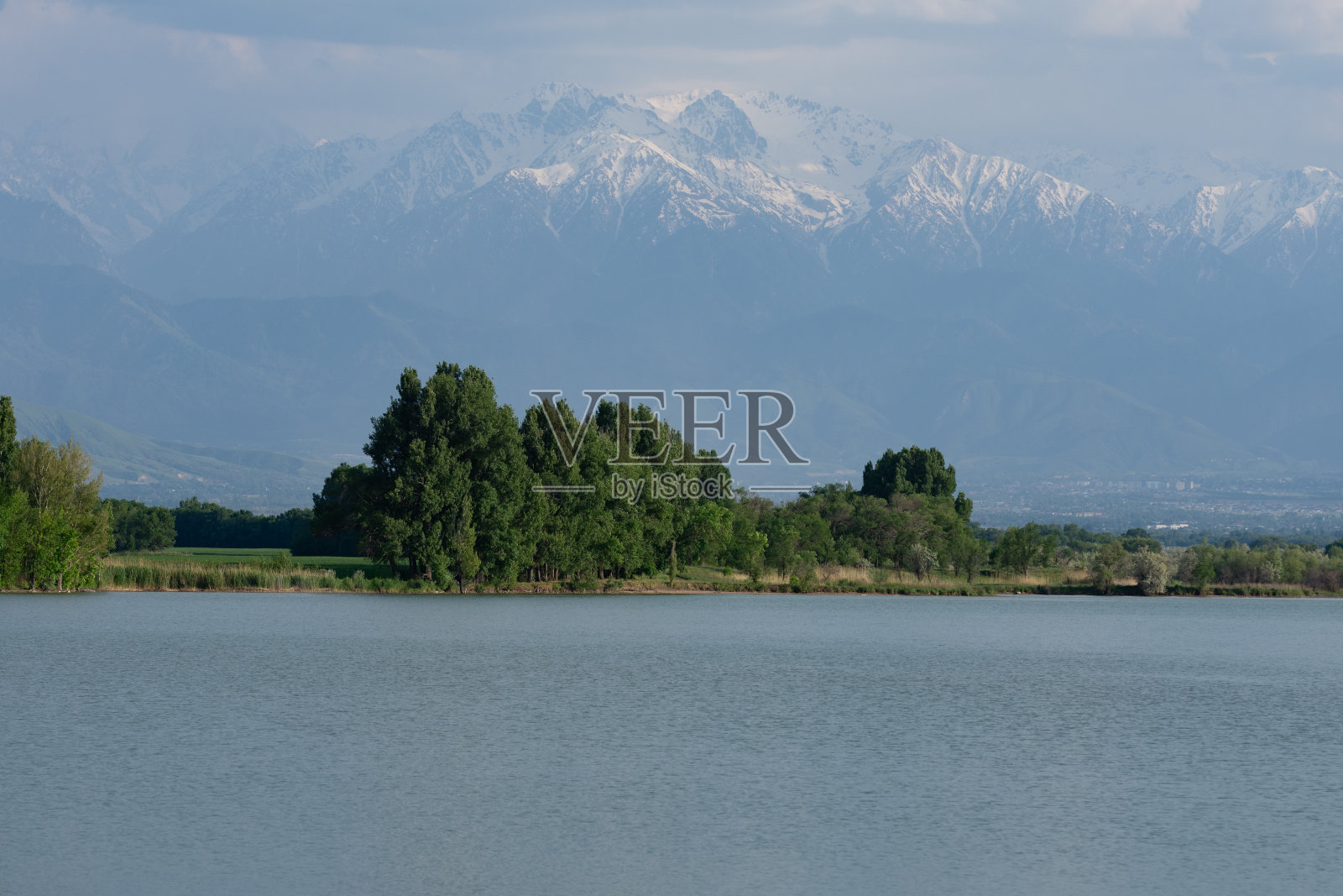 美丽的乡村风光，湖的背景是雪山。照片摄影图片