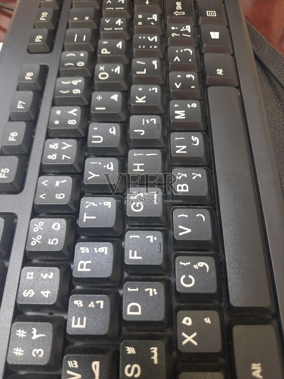带有白色阿拉伯语和英语字母和数字的黑色电脑键盘照片摄影图片