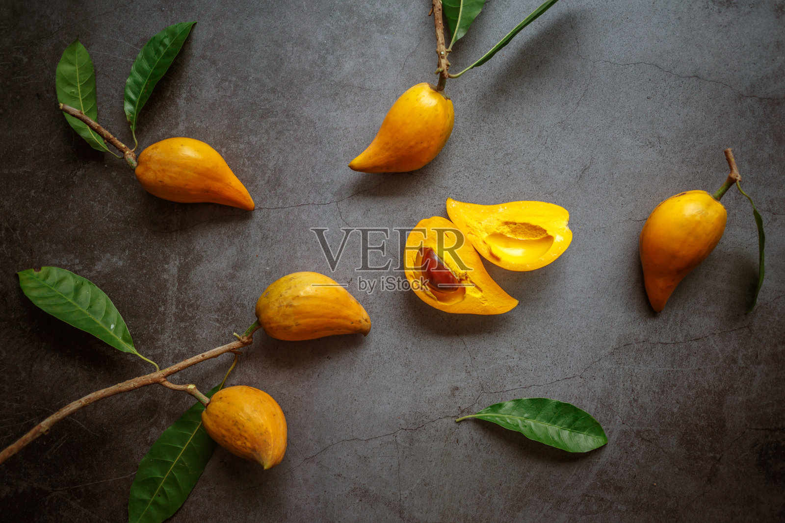 切成两半的Canistel, Tiesa，黄色仙人掌，Pouteria Campechiana,Canistel，成熟，橙色，灰色背景，俯视图，很多照片摄影图片