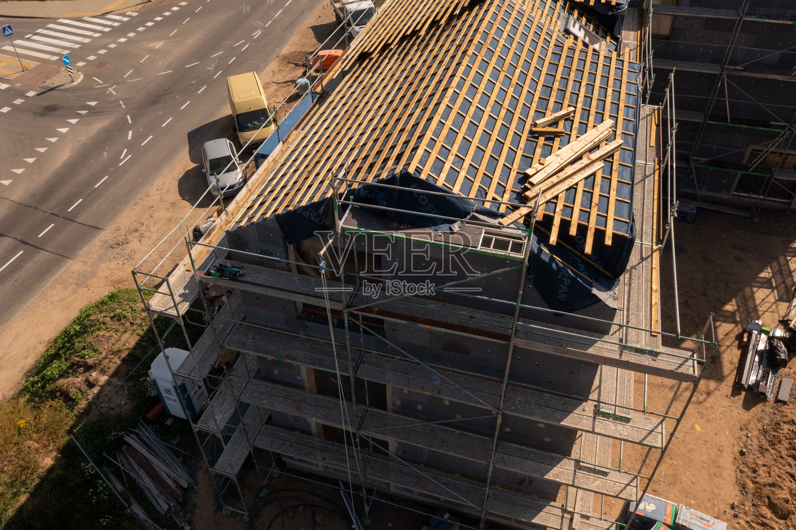无人机拍摄的新住宅建筑工地，脚手架和屋顶照片摄影图片
