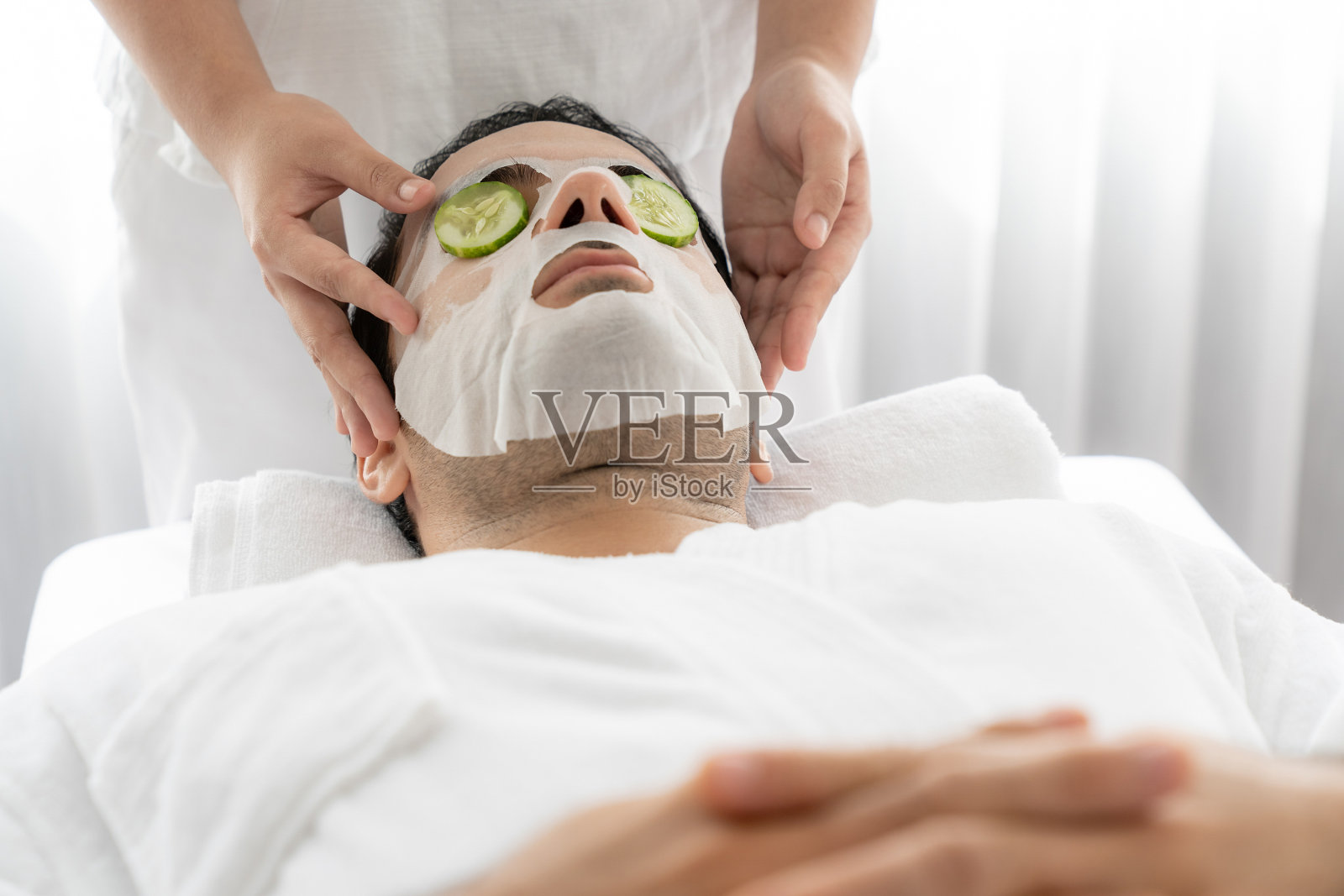 许多顾客沉迷于用黄瓜做面部护理来恢复活力。静照片摄影图片