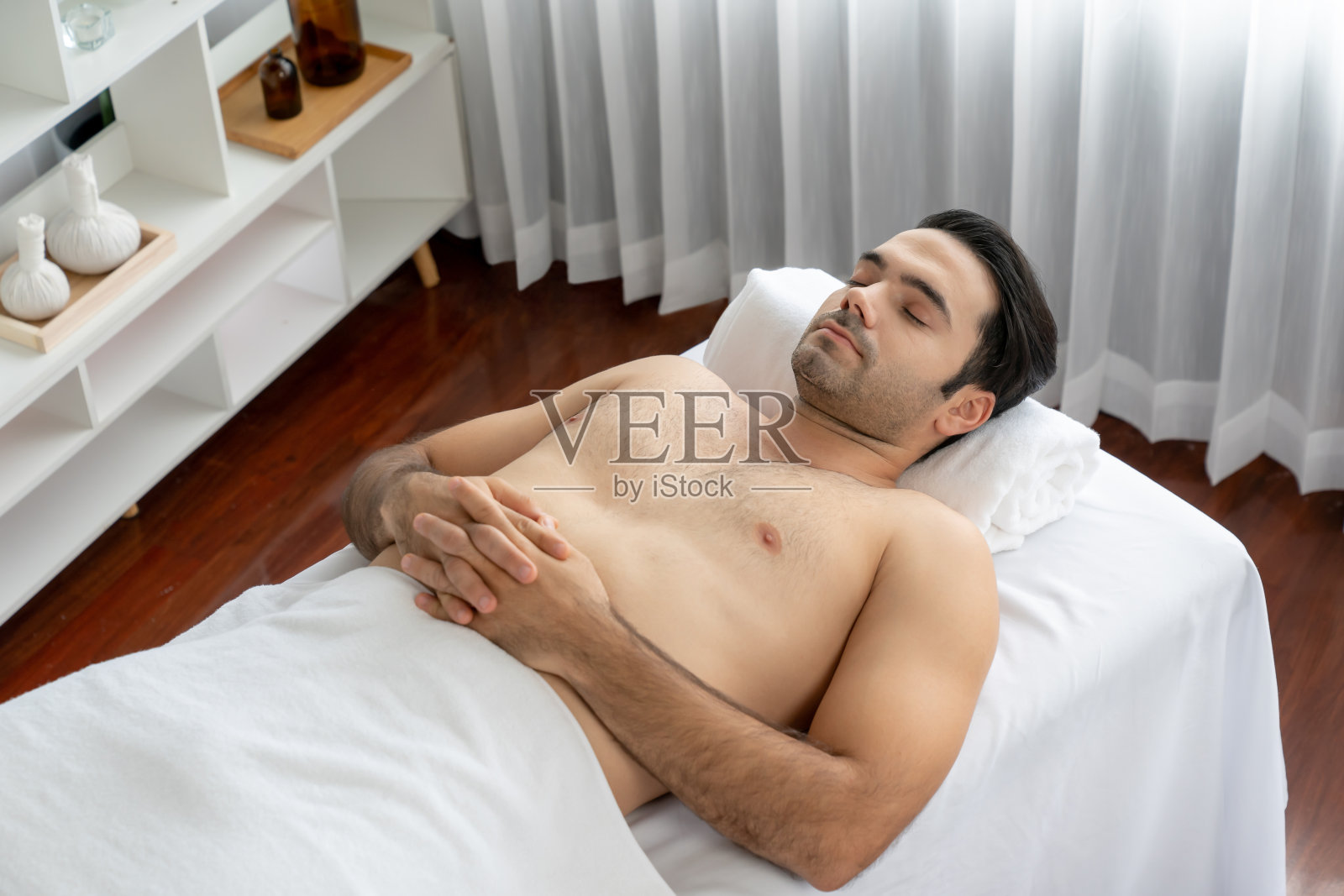 白人男性客户享受放松的抗压力按摩。静照片摄影图片