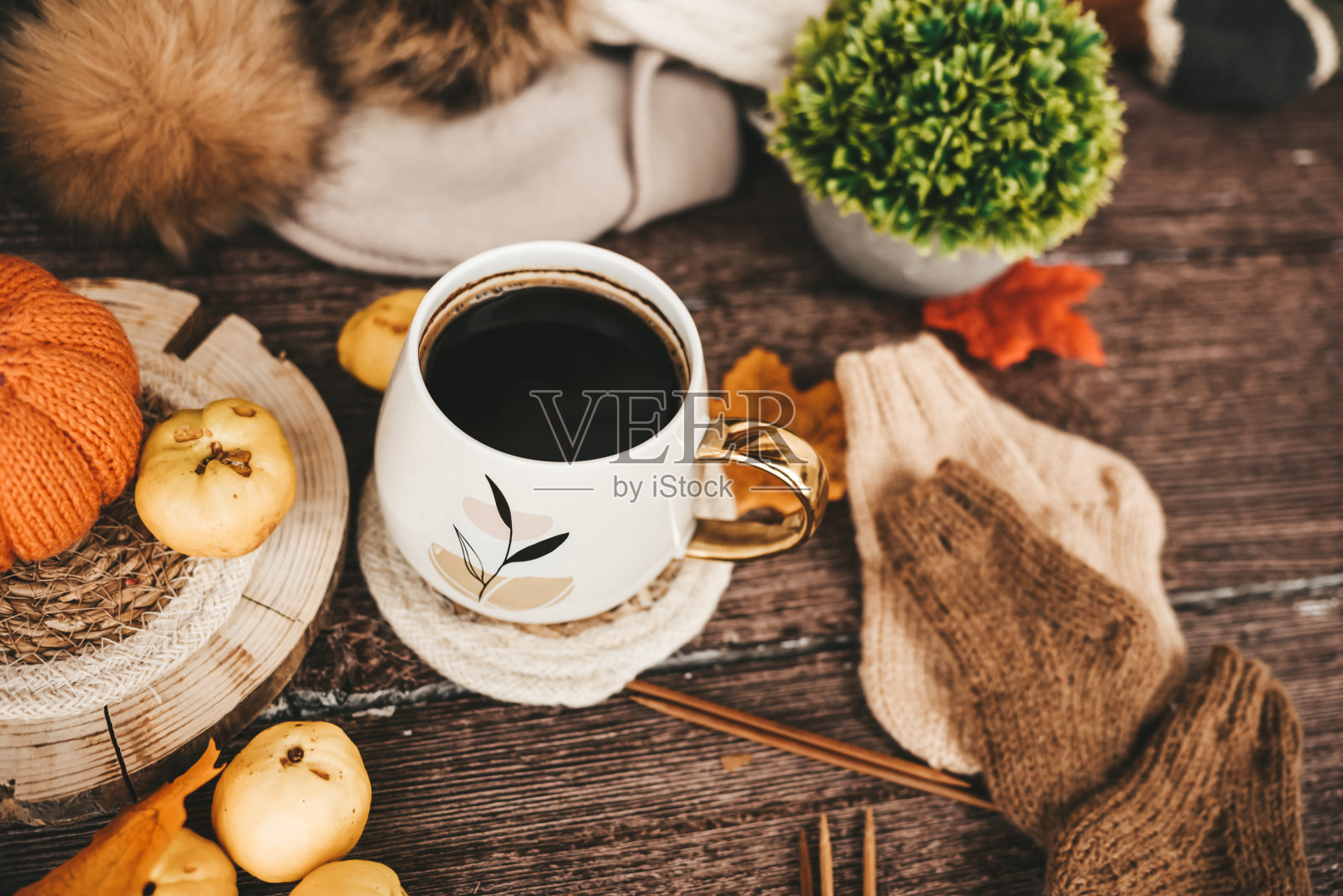 一杯咖啡与秋叶和编织围巾在木制背景照片摄影图片