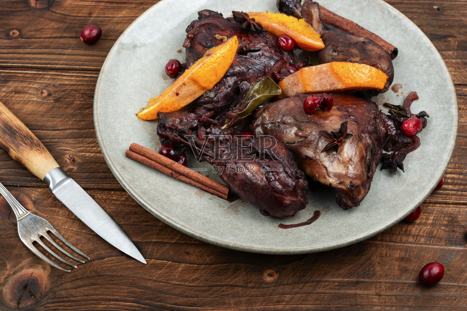 烤鸡腿配橘子和浆果。照片摄影图片