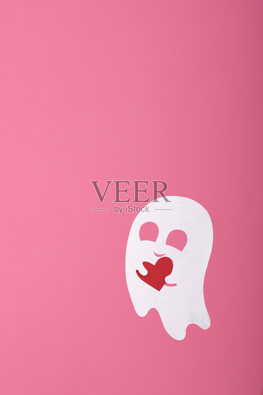 纸鬼恋爱用一颗心在粉红色的背景上照片摄影图片