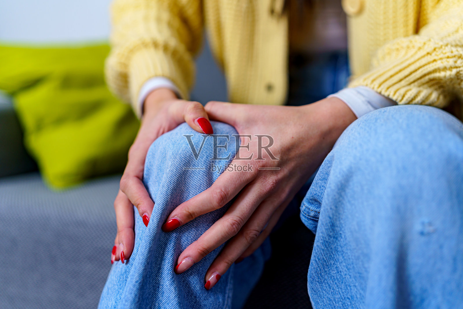 一个年轻女子的手握住她受伤的膝盖的特写照片摄影图片