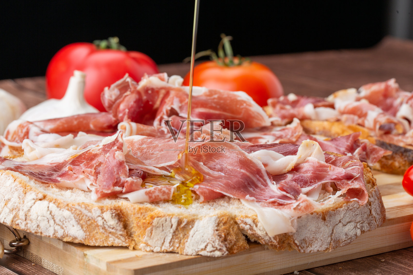 伊比利亚火腿放在质朴的木头上，美味佳肴。照片摄影图片