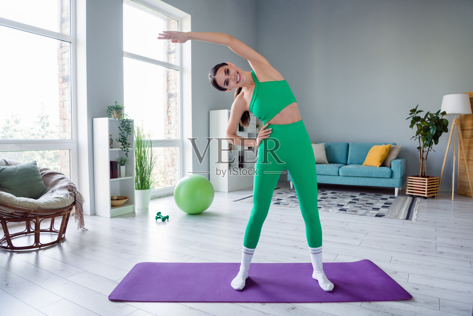 迷人苗条的女士穿着运动装微笑伸展回到室内家庭工作室的全长照片照片摄影图片