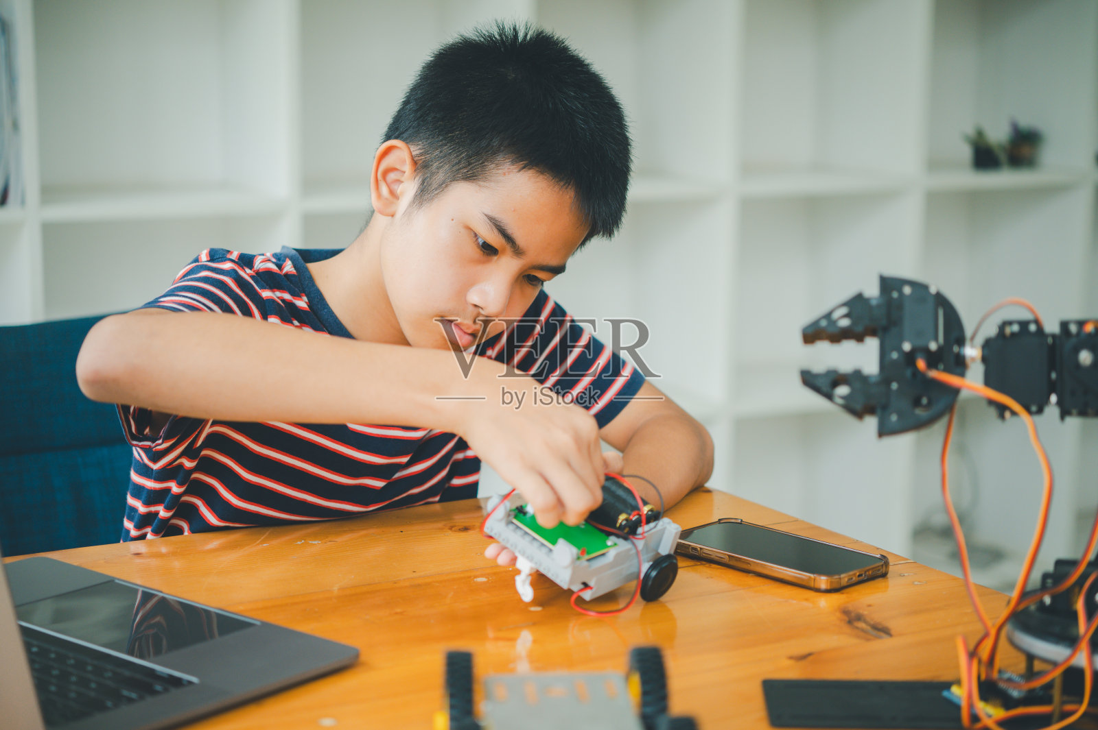 亚洲男孩学习和研究技术机器人的工作。家庭教育和科学换技术项目。童年玩耍，孩子爱好，休闲生活，人们玩具，机器人技术。照片摄影图片