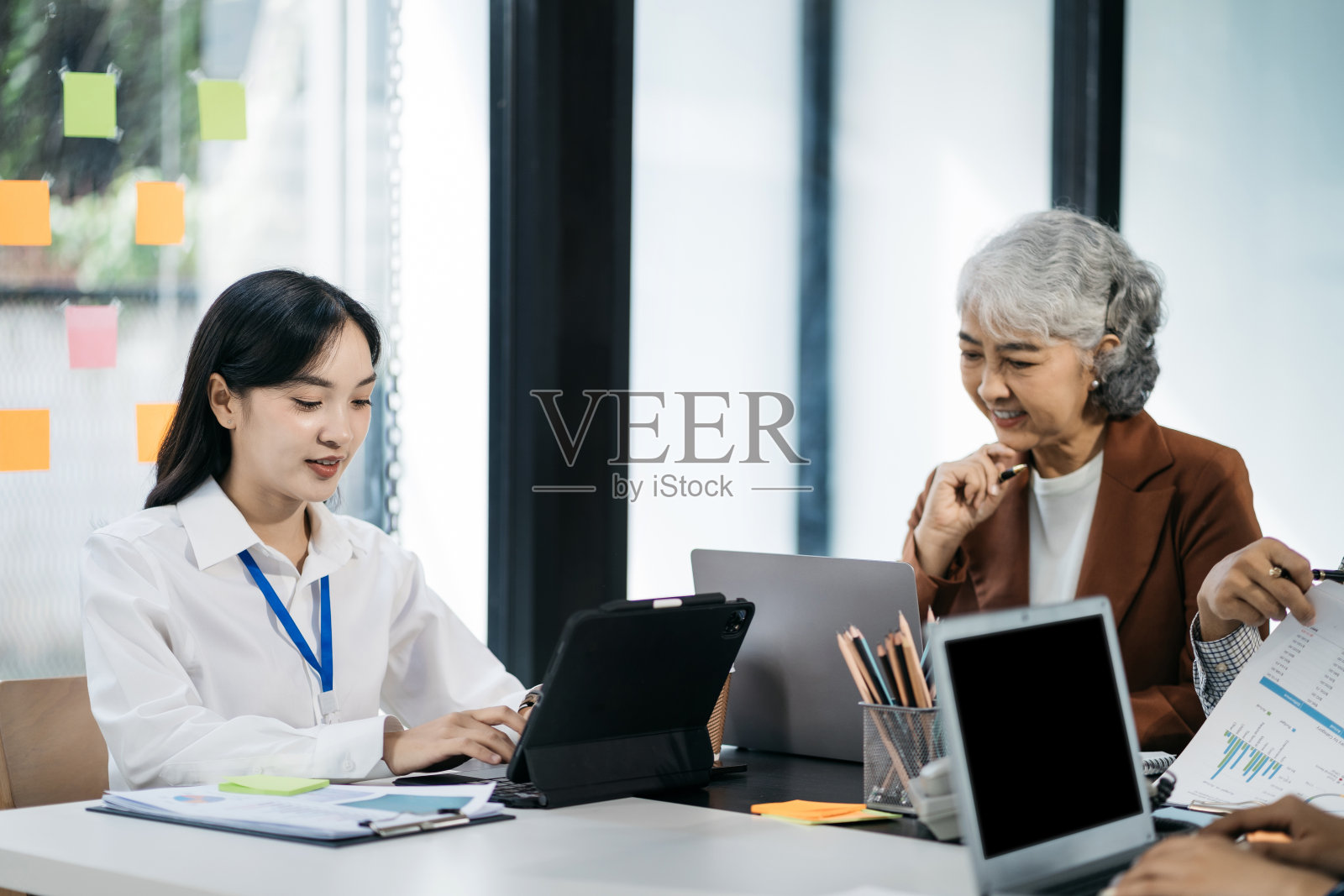 一群年轻的亚洲商业团队，有创意的商业人士在办公室同事。分析图公司财务会议报告。人们在商务办公室工作。照片摄影图片