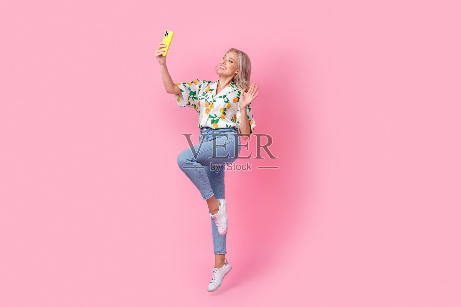 积极的博主年轻女子挥舞手掌干部自拍跳跃skype视频电话孤立在粉红色的背景照片摄影图片